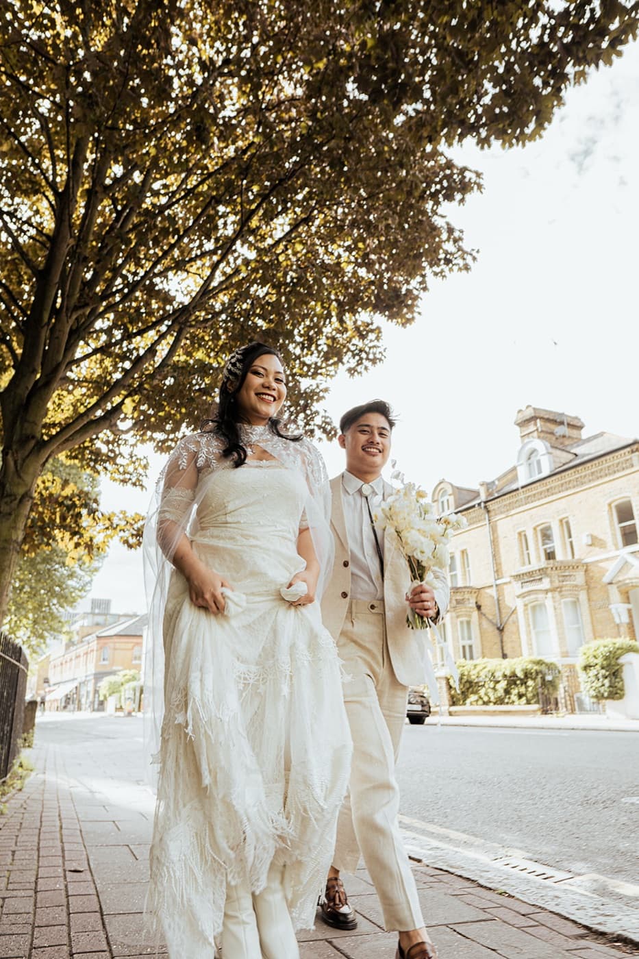 Wedding couple walking in the streets of London by Evocation Photography