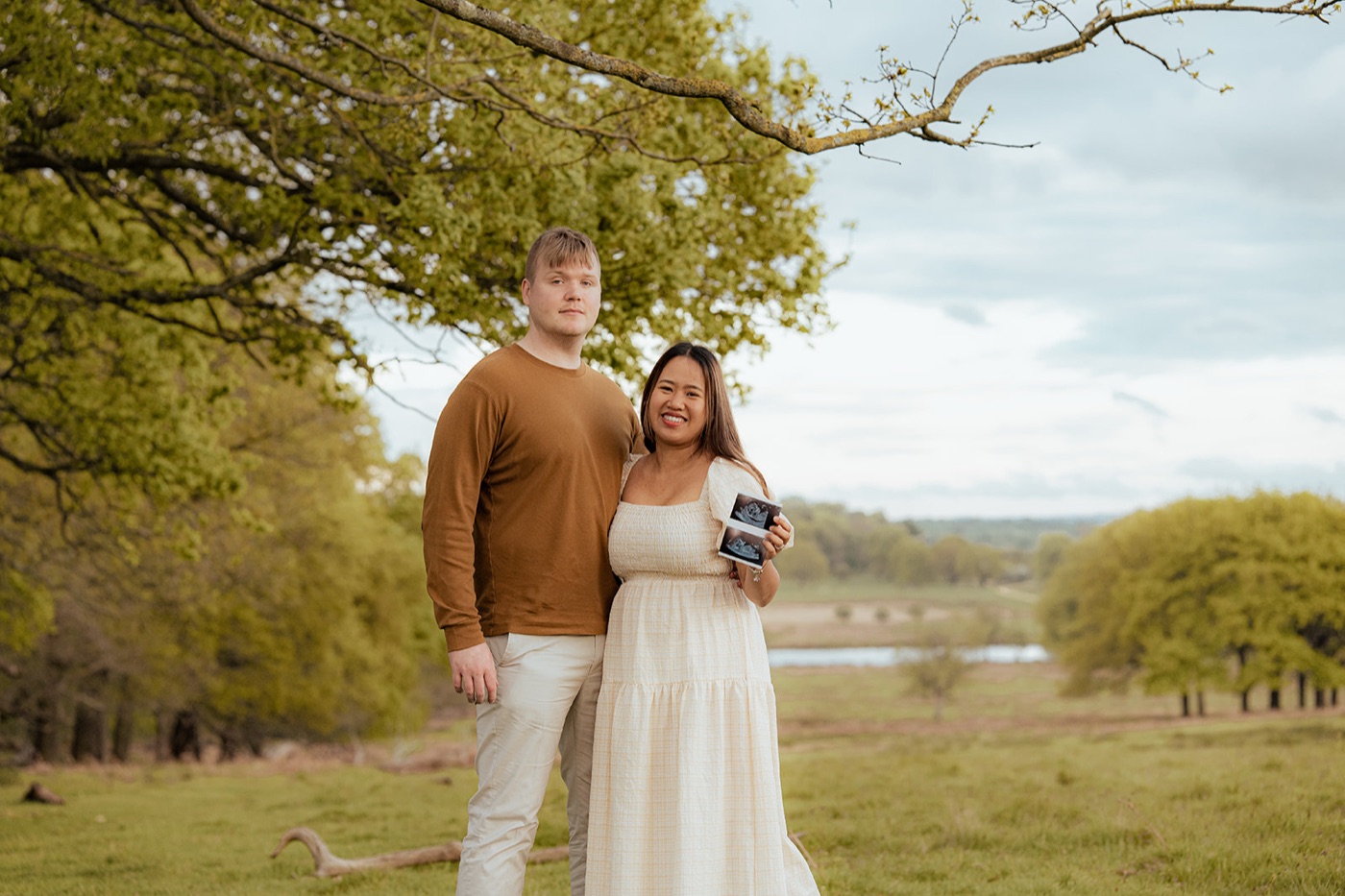 Family portrait with baby reveal announcement in a park — London